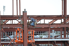 Construction worker working on top of the beam